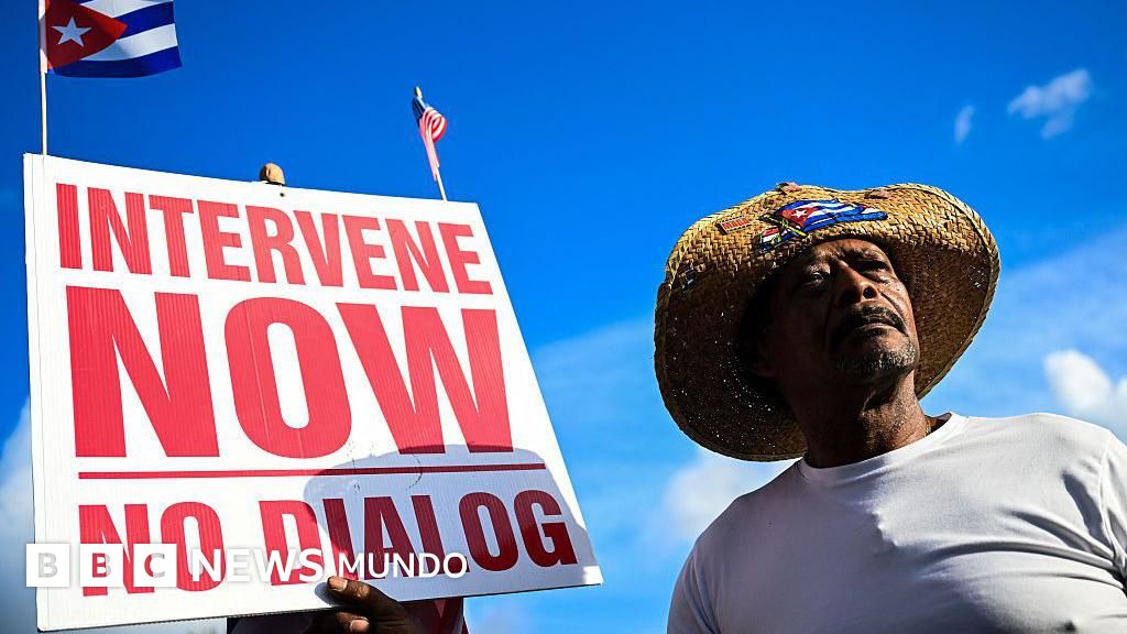 Un hombre sosteniendo un cartel que dice “intervengan ahora” en Miami, Florida.